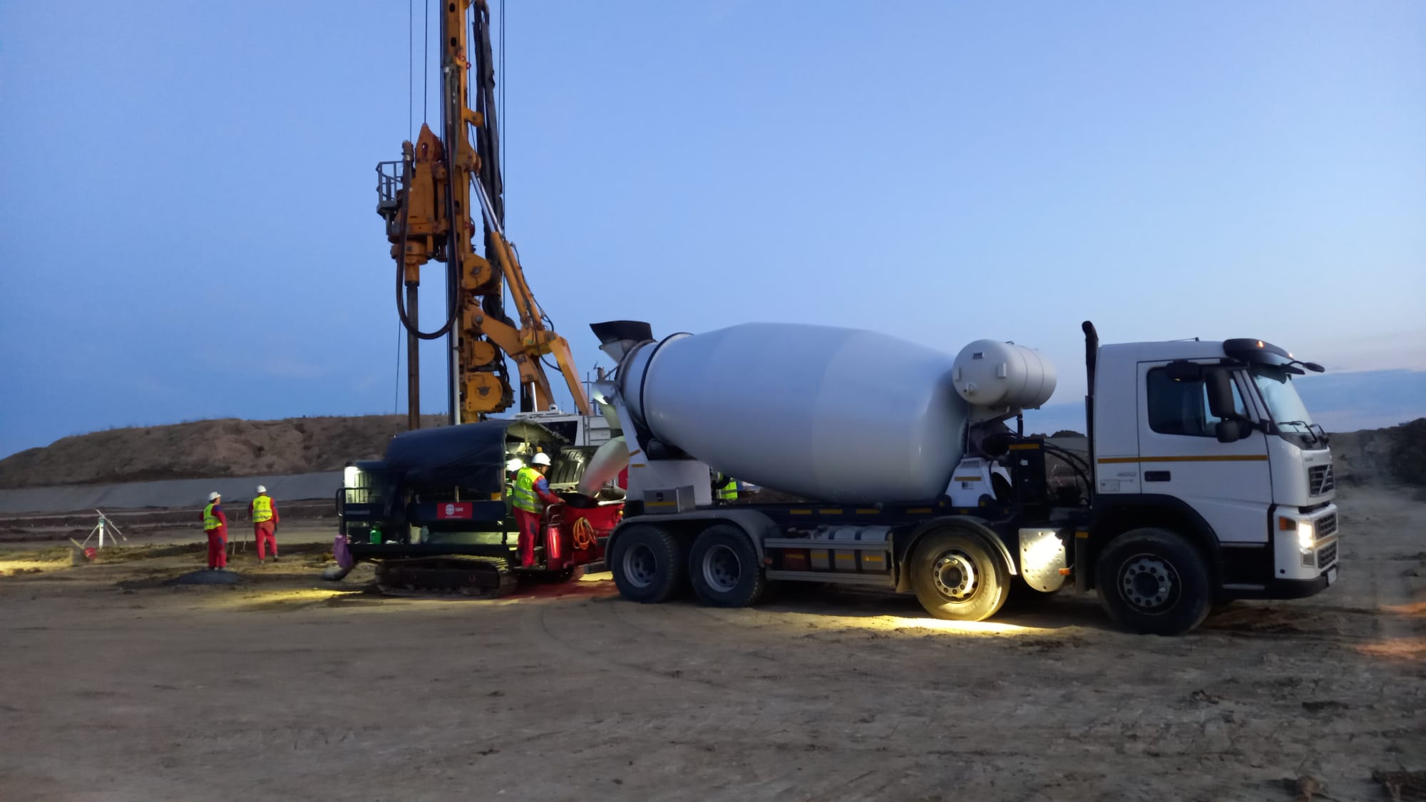 Autobetonieră AMI Beton și utilaje de pompare pe șantier în Iași, seara